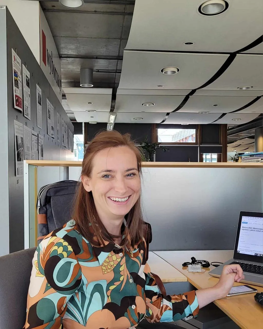 Kalina Kalwasińska at a desk in the Gazeta Wyborcza newsroom, smiling at the camera