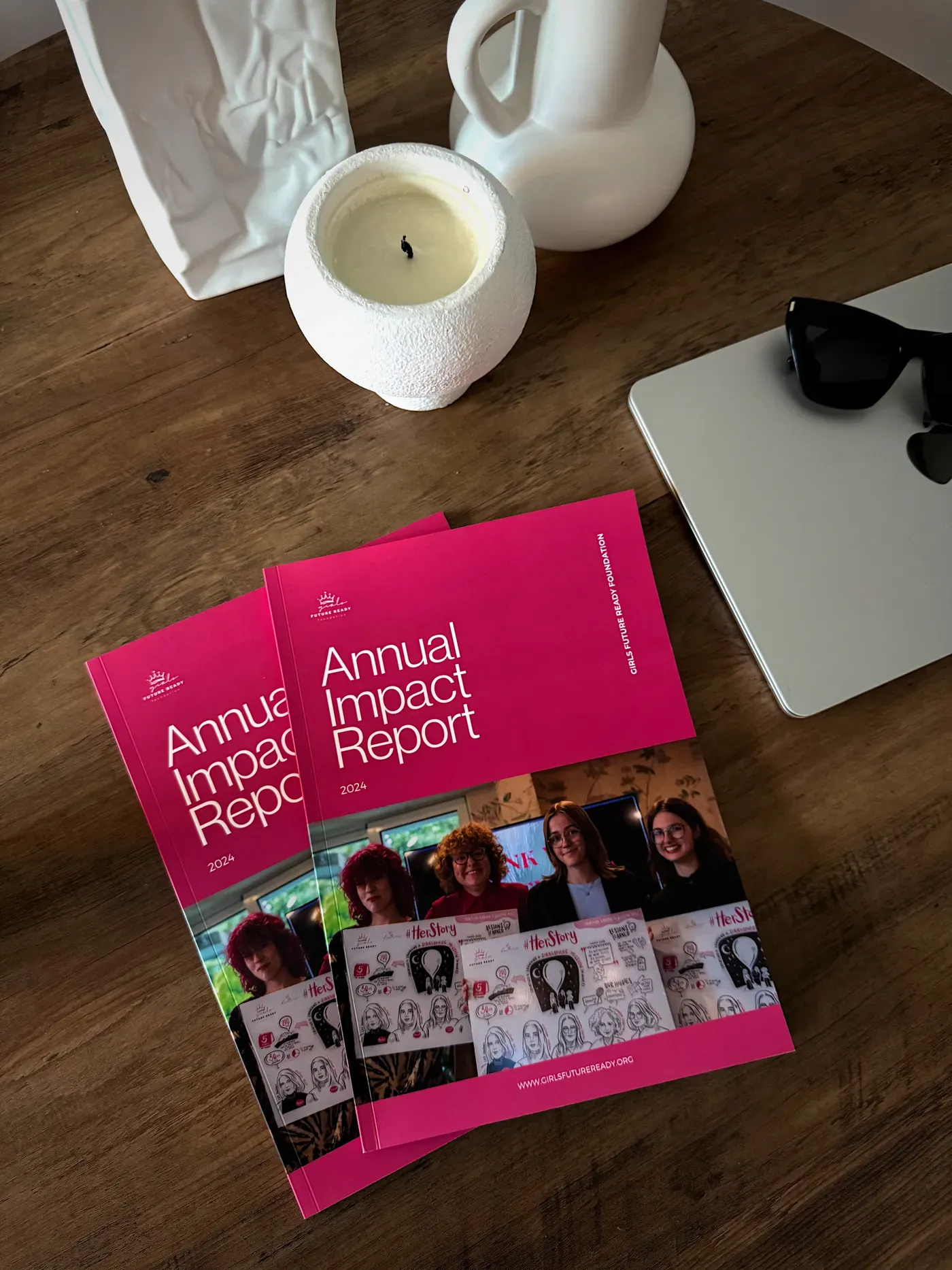 Printed copies of the Girls Future Ready Annual Impact Report on a desk