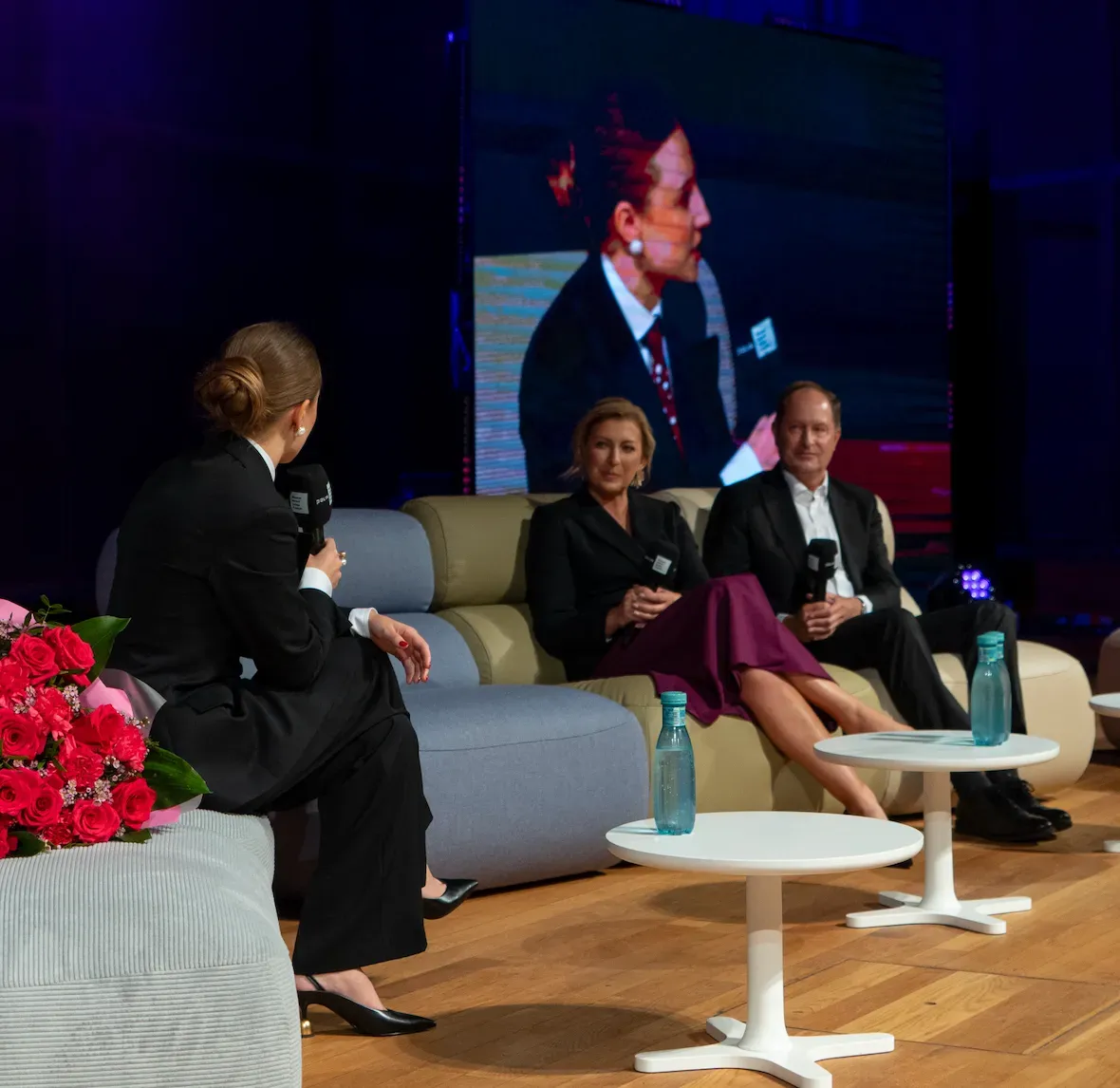 A panel discussion on stage at the Girls Future Ready Summit, a speaker on the screen behind